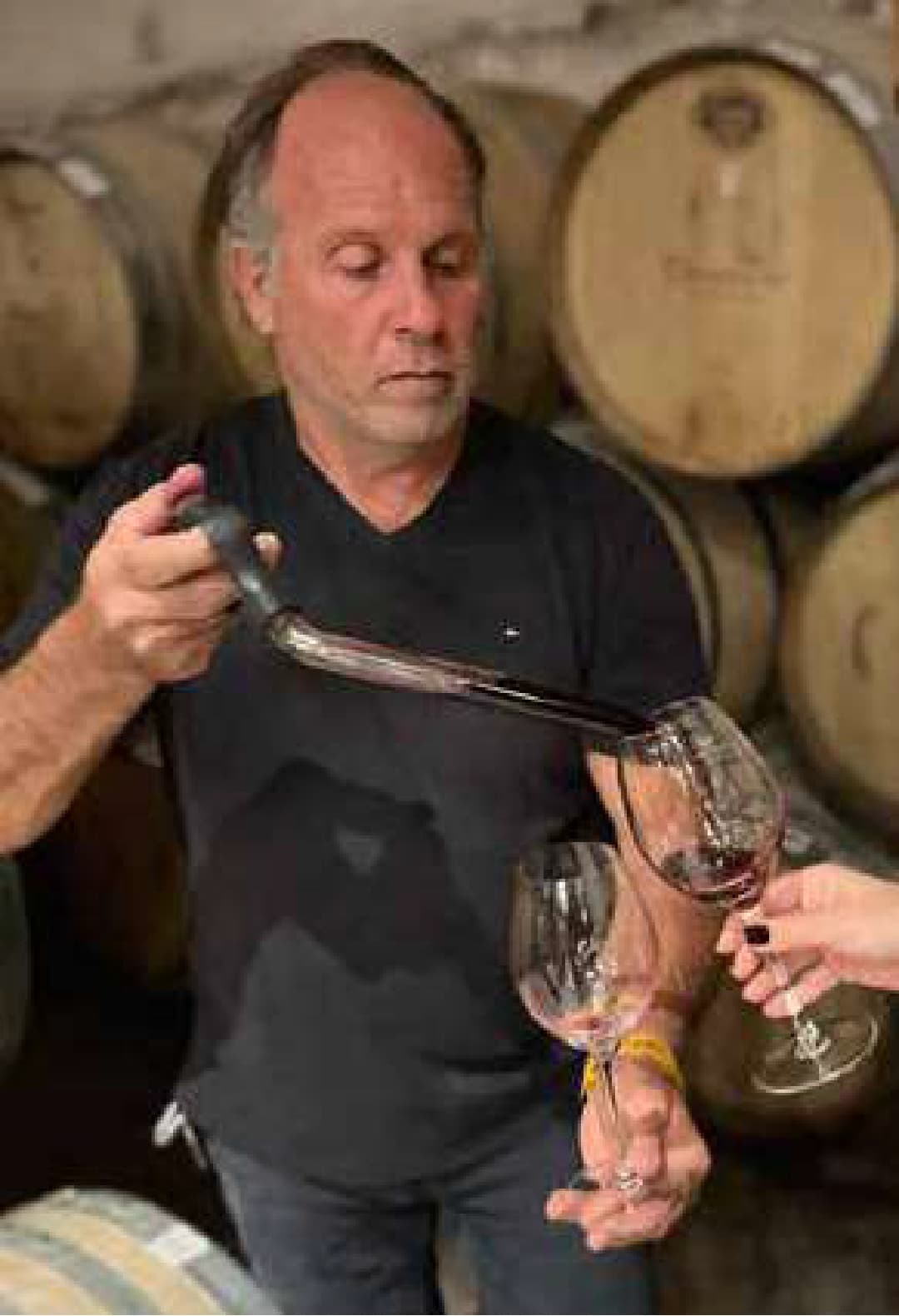 Alberto Benenati degustando vino con pipeta entre barricas de roble