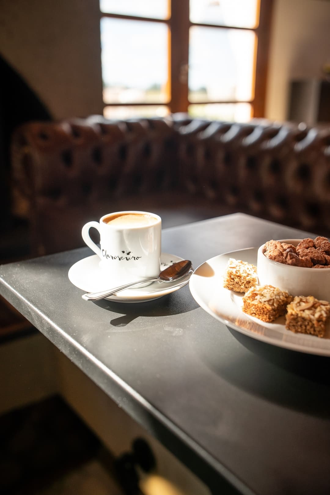 Café Claroscuro y petit fours sobre barra de mármol